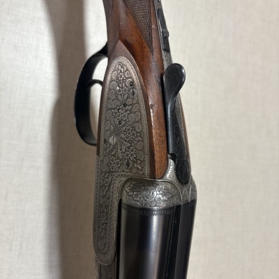 Espingarda com cabo de madeira castanha e gravações em metal prateado