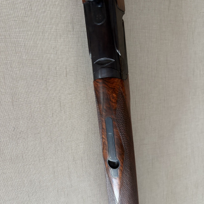 Rifle ou espingarda com cabo em madeira trabalhada castanha escura e parte metálica preta