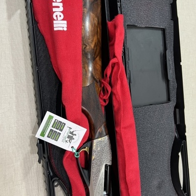 Estojo aberto com espingarda Benelli protegida por tecido vermelho com logo Benelli