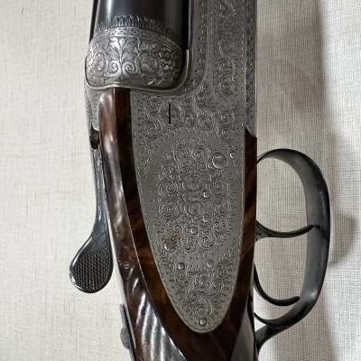 Espingarda de canos duplos com gravações ornamentais e madeira polida
