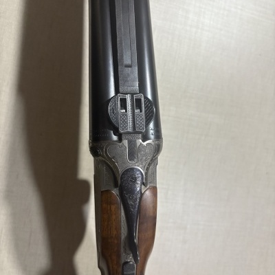 Espingarda de canos duplos com empunhadura de madeira e detalhes metálicos