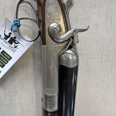 Espingarda de caça com cabo de madeira e partes metálicas prateadas