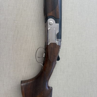 Espingarda Beretta 692 com madeira castanha, metal prateado e textura na coronha