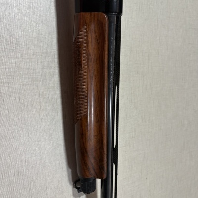 Espingarda Benelli com cabo de madeira castanha e cano preto