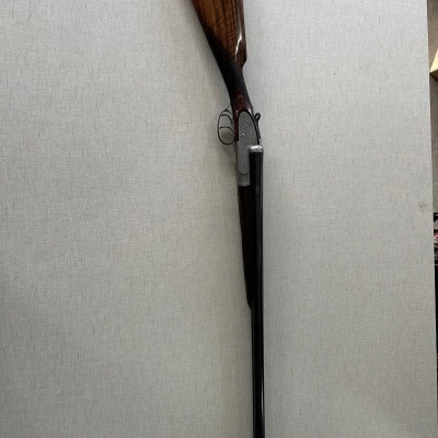 Espingarda de cano duplo com coronha castanha e detalhes metálicos prateados