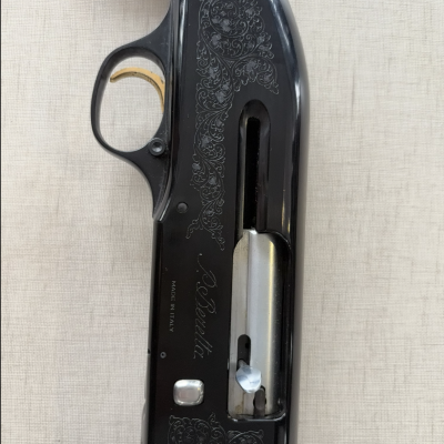Parte central de espingarda Beretta com madeira castanha e metal preto gravado 