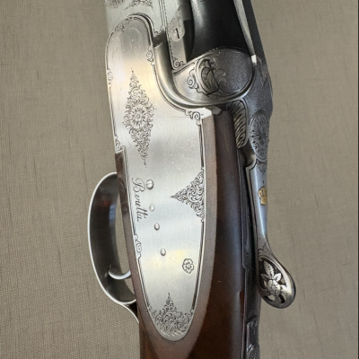 Espingarda com madeira castanha e detalhes em metal prateado gravado