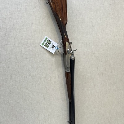 Espingarda de canos duplos com coronha em madeira castanha e metal preto