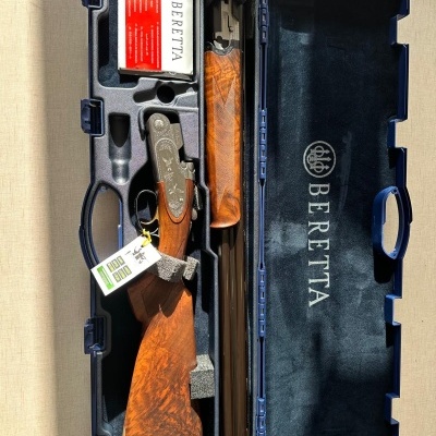 Espingarda de canos duplos com coronha em madeira numa mala azul com o logótipo BERETTA