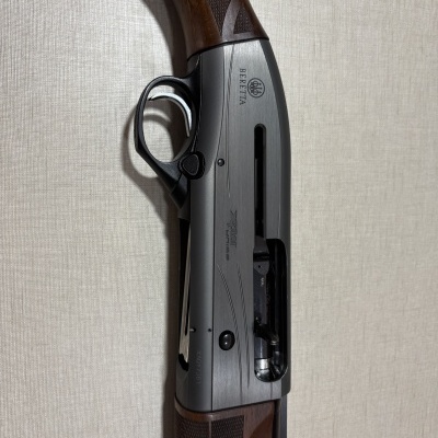 Espingarda semiautomática Beretta em madeira e metal cinza escuro com gatilho prateado