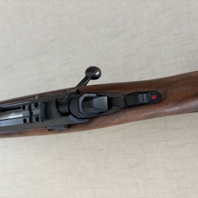 Carabina com coronha de madeira escura e mecanismos metálicos pretos
