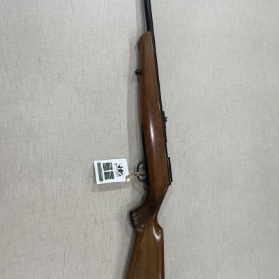 Carabina com coronha em madeira castanha e cano preto sobre superfície cinza