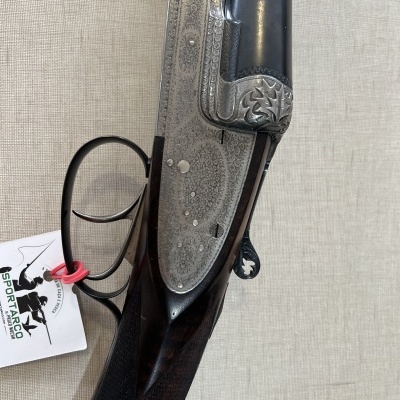 Espingarda de canos duplos com gravações em metal e coronha em madeira escura