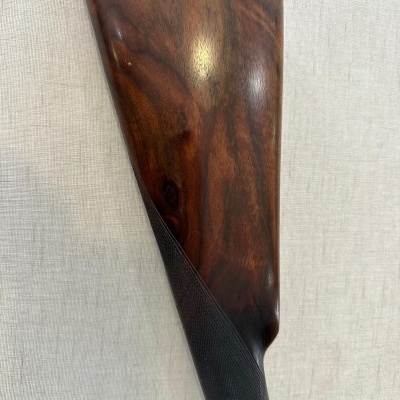 Coronha de espingarda em madeira castanha com parte inferior texturizada cinza escura