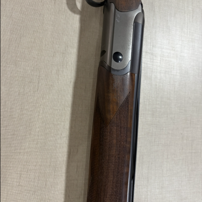 Espingarda com cabo e coronha em madeira e metal prateado fosco.