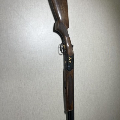 Espingarda de cano duplo com madeira castanha e detalhes dourados