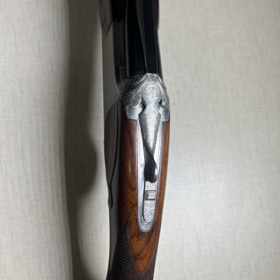 Espingarda de canos paralelos com madeira castanha e metal gravado