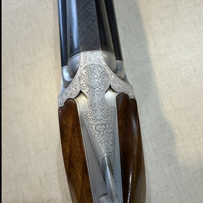 Espingarda de canos duplos com gravuras florais no metal e coronha de madeira