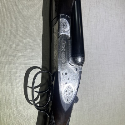 Espingarda de canos duplos com detalhe em metal prateado gravado e corpo em madeira escura