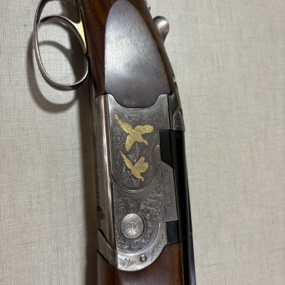 Espingarda de madeira e metal gravado com imagens de aves douradas BERETTA