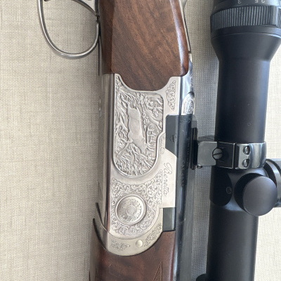 Rifle de caça com coronha em madeira e luneta preta com inscrições