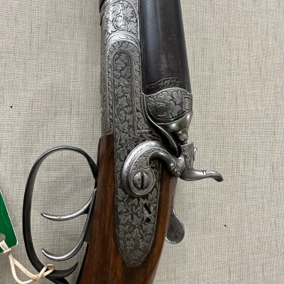 Espingarda de cano duplo com acabamentos metálicos gravados e coronha em madeira