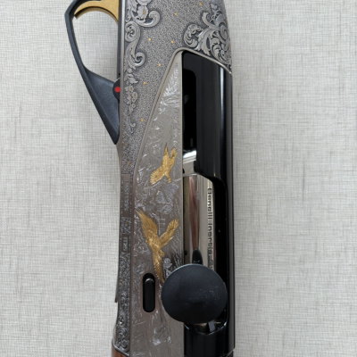 Espingarda com gravações decorativas em metal e madeira.