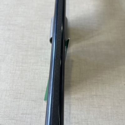 Produto preto com acabamento texturizado sobre superfície cinza claro