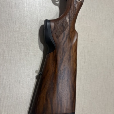 Coronha de espingarda em madeira castanha com punho xadrezado e apoio de borracha