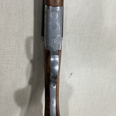 Espingarda com madeira e metal prateado em fundo branco texturizado