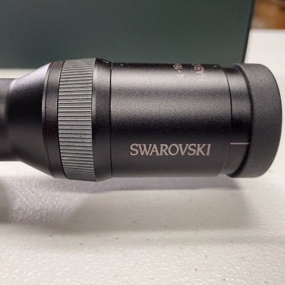 Óptica preta da marca Swarovski com anel texturizado e texto visível