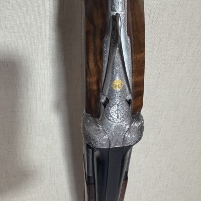 Parte superior de espingarda com metal gravado e madeira castanha escura