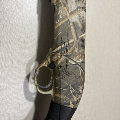 Espingarda camuflada com texto D. COXtreme 20 GA PLUS e coronha preta