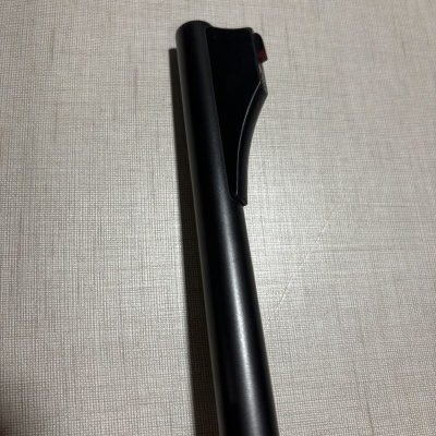 Caneta preta com clip sobre superfície têxtil bege