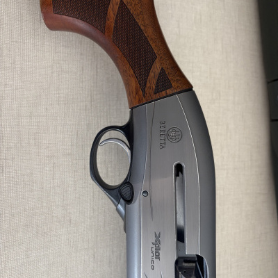 Espingarda semiautomática com coronha em madeira castanha e detalhes em metal cinza com inscrições BERETTA e XPLOR UNICO