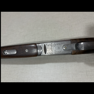 Espingarda com madeira escura e metal gravado