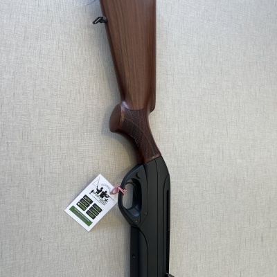 Espingarda de madeira e metal com etiqueta pendurada em fundo cinza