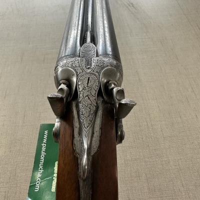 Espingarda de caça com detalhes metálicos gravados e madeira