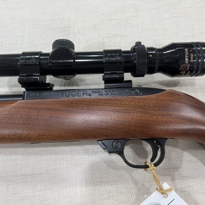 Rifle com coronha de madeira castanha e luneta telescópica preta montada