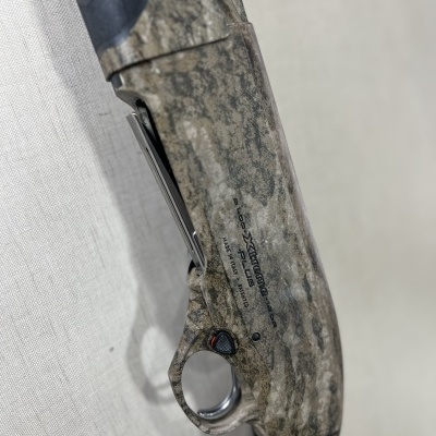 Espingarda com padrão camuflado em tons de cinza e bege