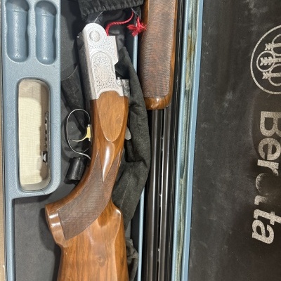 Espingarda com coronha em madeira e parte metálica gravada numa mala com forro preto e a marca Beretta