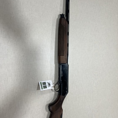 Espingarda com madeira castanha e metal preto com etiqueta pendurada