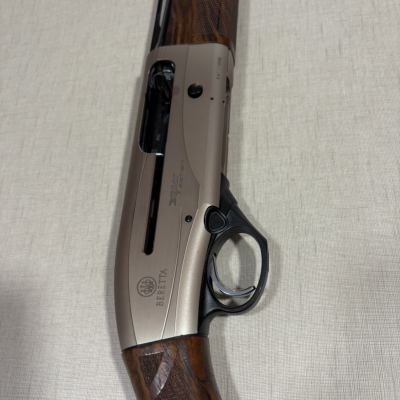 Espingarda Beretta com corpo metálico e detalhes em madeira sobre superfície clara