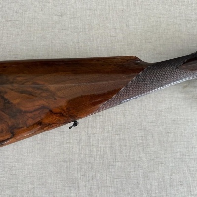 Coronha de espingarda em madeira escura com detalhe em relevo e etiqueta verde