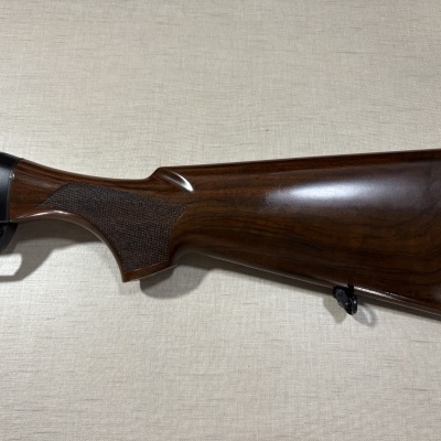 Espingarda com coronha em madeira castanha polida com textura na pega