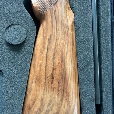 Coronha de madeira castanha numa caixa de espuma preta com cavidades