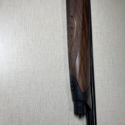 Arma com cabo de madeira entalhada e metal preto