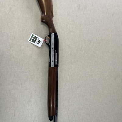 espingarda de caça com madeira castanha e cano preto numa superfície clara