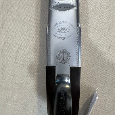 Parte superior de espingarda com metal gravado e punho em madeira escura