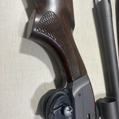 Parte de arma de fogo com empunhadura em madeira e cadeado numérico preto